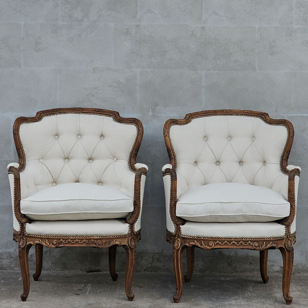 Par de sillones estilo francés Luis XV tallados tapizados en lino